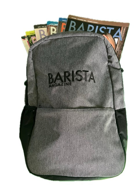 Gray backpack with 'Barista Magazine' branding, filled with magazines.