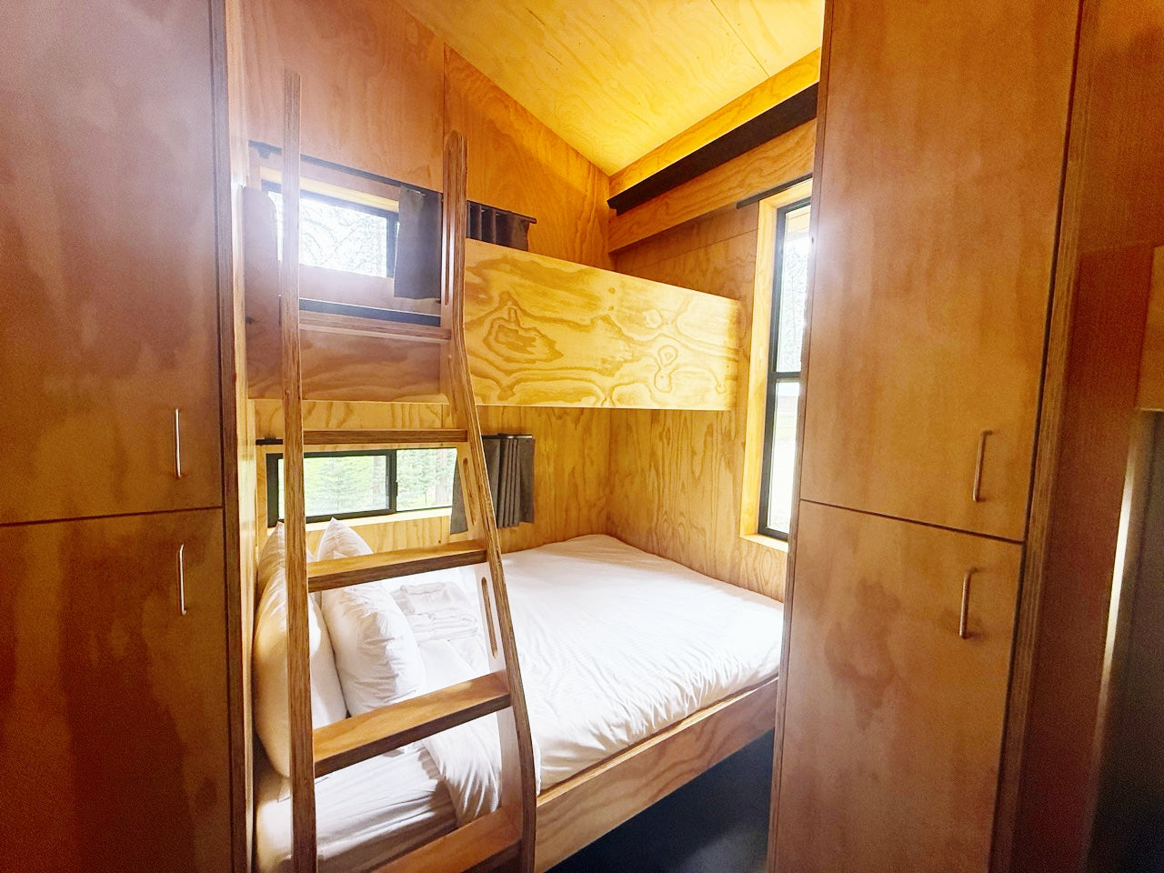 Wooden bunk bed with ladder in a bunkhouse