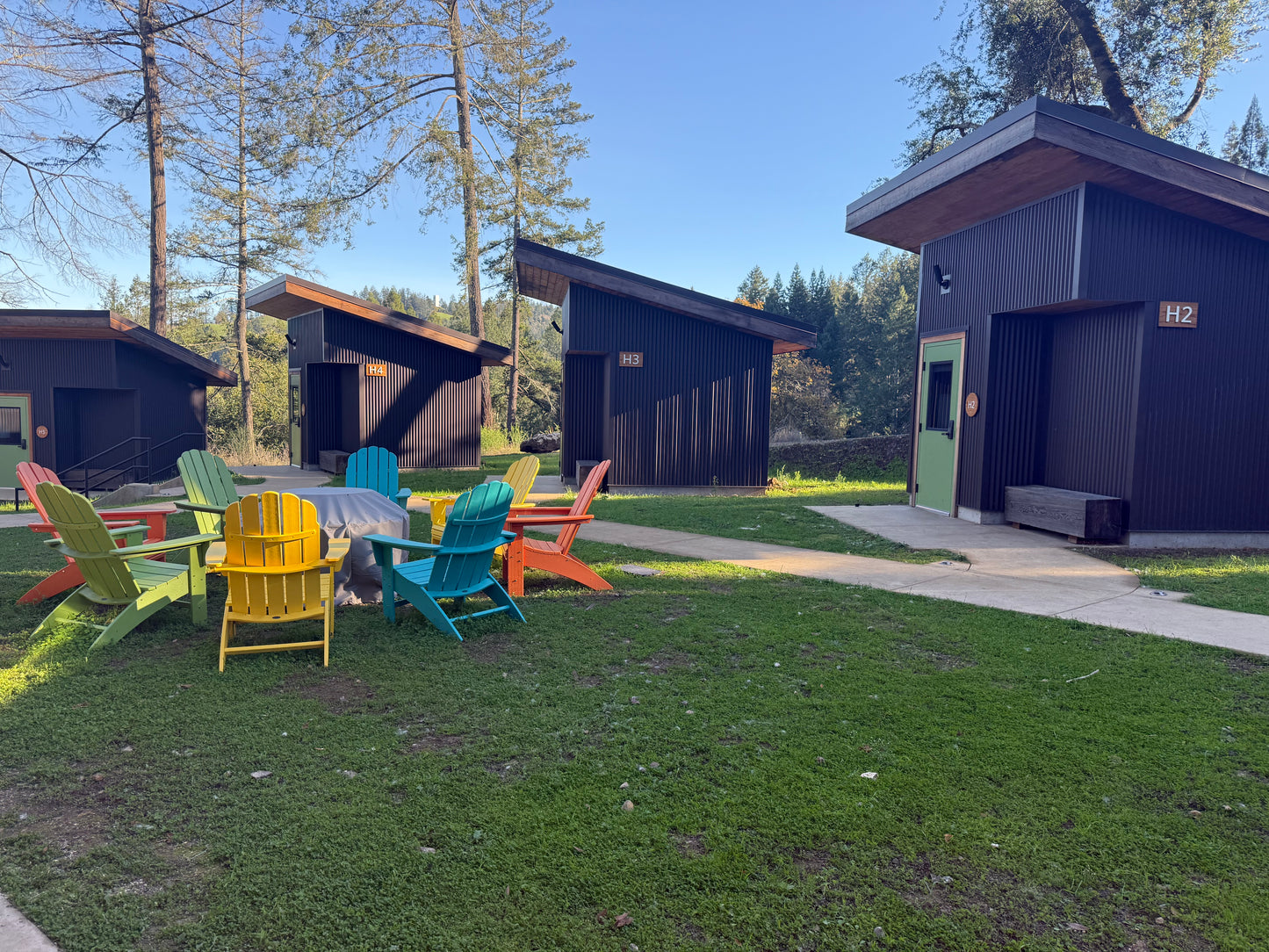 Colorful outdoor furniture set in front of casitas with trees in the background