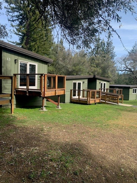 Lakeside cabins with wooden decks in a forested area