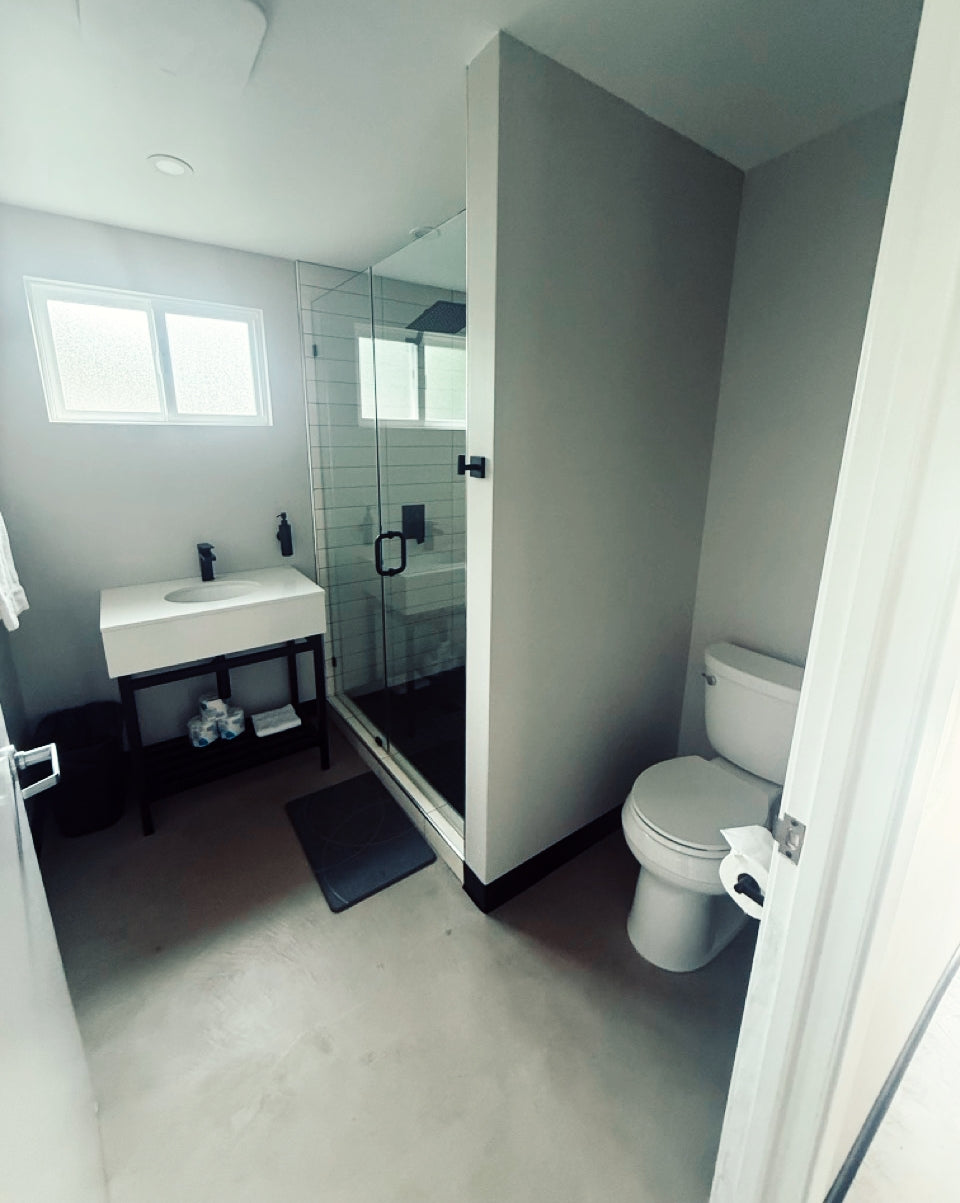 Lakeside cabin bathroom with toilet, sink, and shower in a compact space