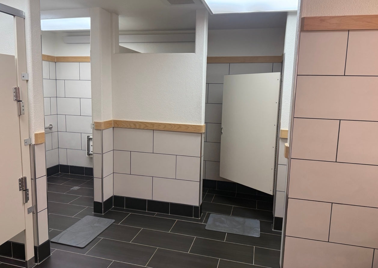 Lodge showers with tiled walls and floor, including a shower area.